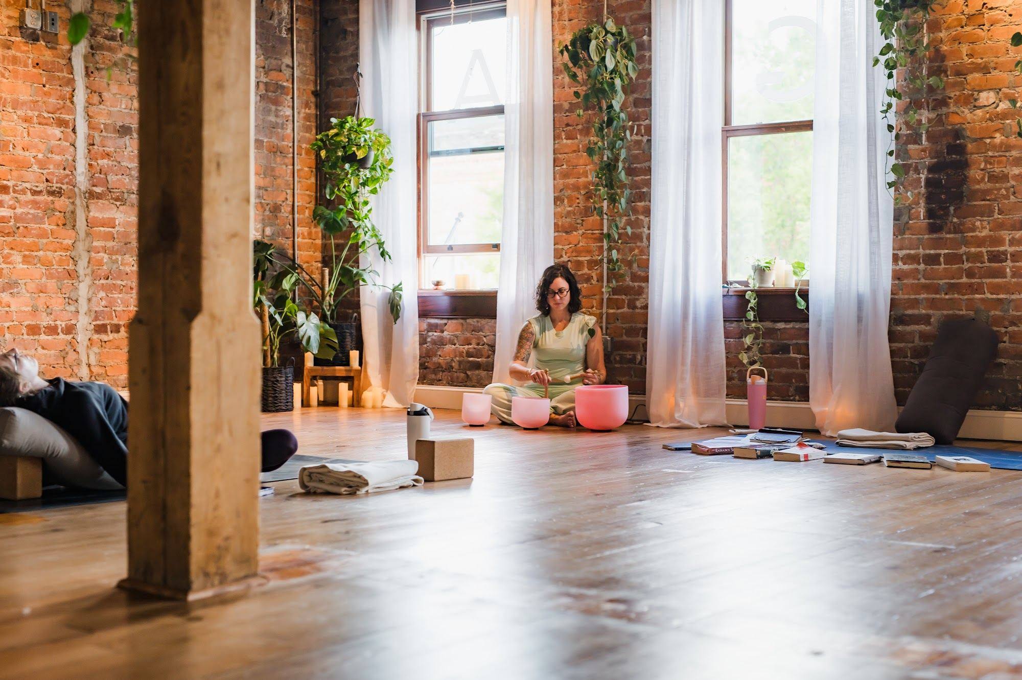 A teacher playing singing bowls while students rest